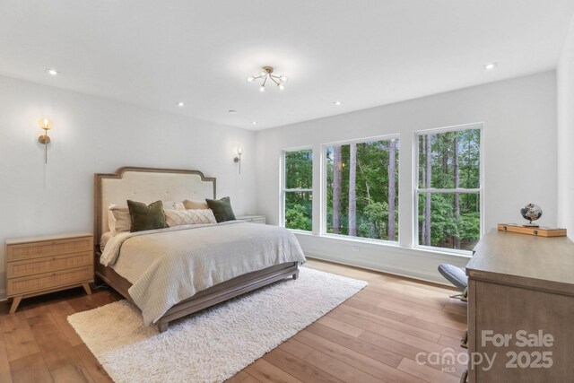 bedroom with multiple windows, light wood-style floors, and recessed lighting