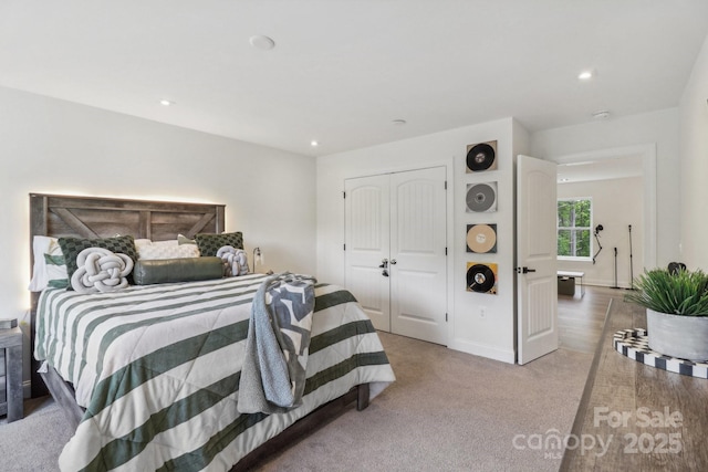 bedroom featuring recessed lighting, a closet, light colored carpet, and baseboards