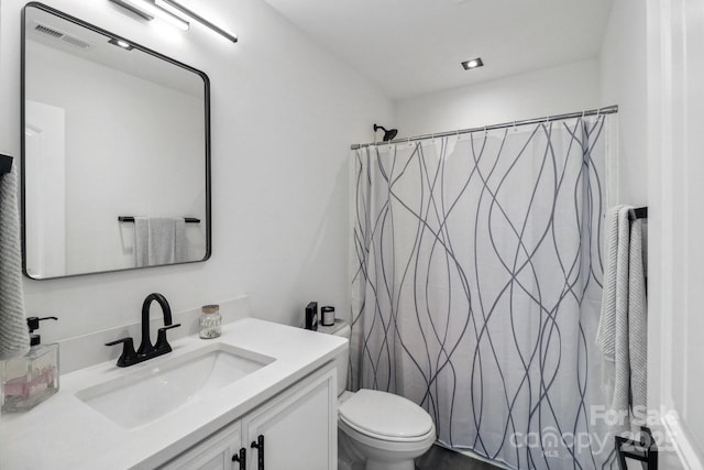 bathroom featuring toilet, vanity, and curtained shower