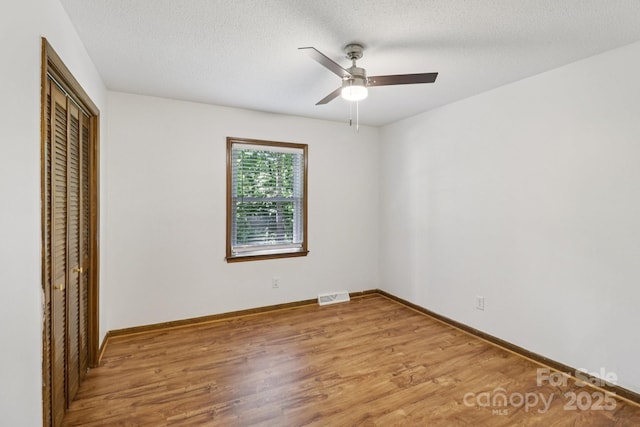 119 Legacy Ln, Harmony, NC 28634 - unfurnished bedroom with a closet, wood finished floors, ceiling fan, and a textured ceiling