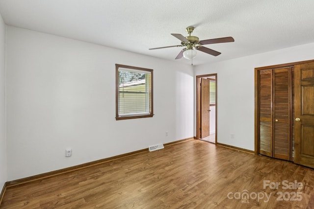 119 Legacy Ln, Harmony, NC 28634 - unfurnished bedroom featuring wood finished floors, a closet, ceiling fan, ensuite bath, and a textured ceiling