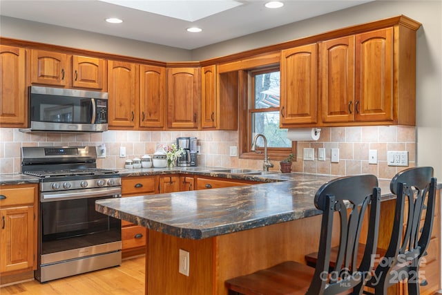 718 Lower Flat Creek Rd, Alexander, NC 28701 - kitchen featuring stainless steel appliances, a sink, brown cabinetry, and recessed lighting