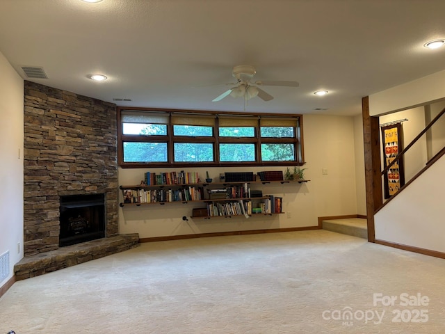 718 Lower Flat Creek Rd, Alexander, NC 28701 - unfurnished living room featuring a ceiling fan, baseboards, carpet, and a stone fireplace