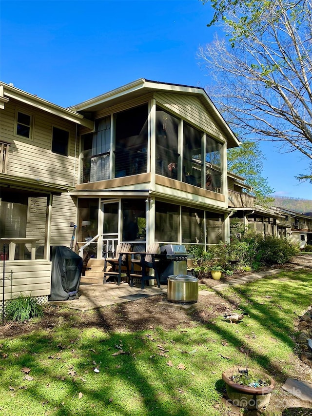 102 W Lake Dr N Unit 106, Lake Lure, NC 28746 - back of property featuring a lawn, a sunroom, and a patio