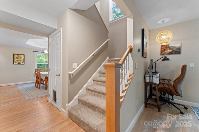 staircase with baseboards and wood finished floors