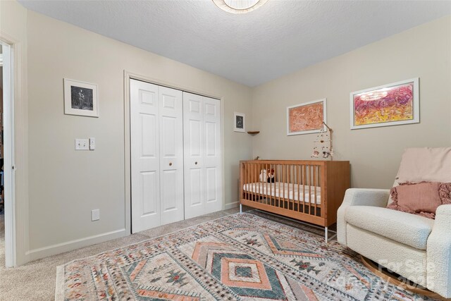bedroom with carpet floors, baseboards, and a closet