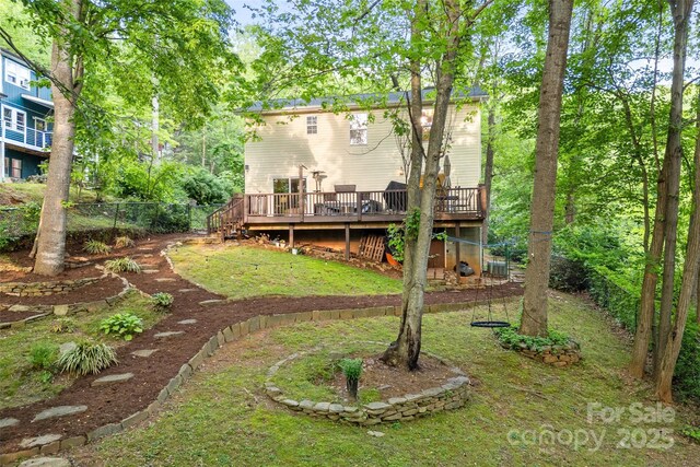 exterior space with a lawn, a wooden deck, stairway, and fence