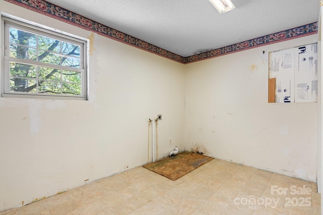 unfurnished room with a textured ceiling