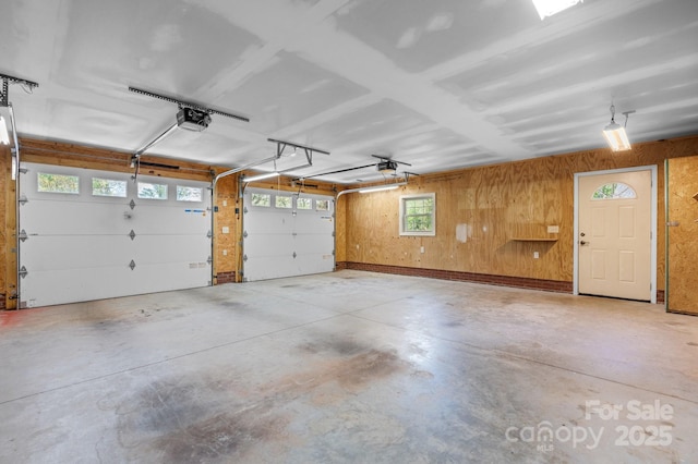 garage featuring wooden walls and a garage door opener