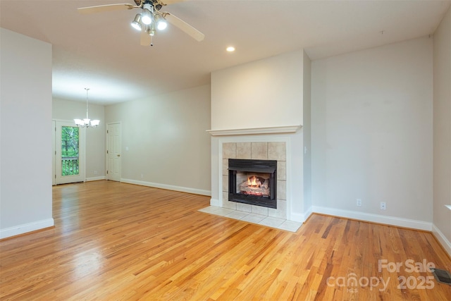 3 Teresa Way, Black Mountain, NC 28711 - unfurnished living room with light wood-style flooring, ceiling fan, a tile fireplace, a chandelier, and recessed lighting