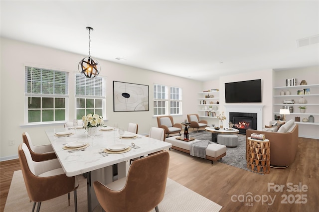 17413 Caddy Ct, Charlotte, NC 28278 - dining area with wood finished floors, a glass covered fireplace, and built in features