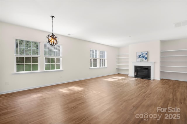 17413 Caddy Ct, Charlotte, NC 28278 - unfurnished living room featuring light wood-style floors, a fireplace with flush hearth, a chandelier, and built in features