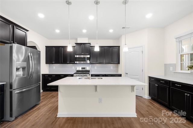 17413 Caddy Ct, Charlotte, NC 28278 - kitchen with appliances with stainless steel finishes, decorative backsplash, wood finished floors, light countertops, and recessed lighting