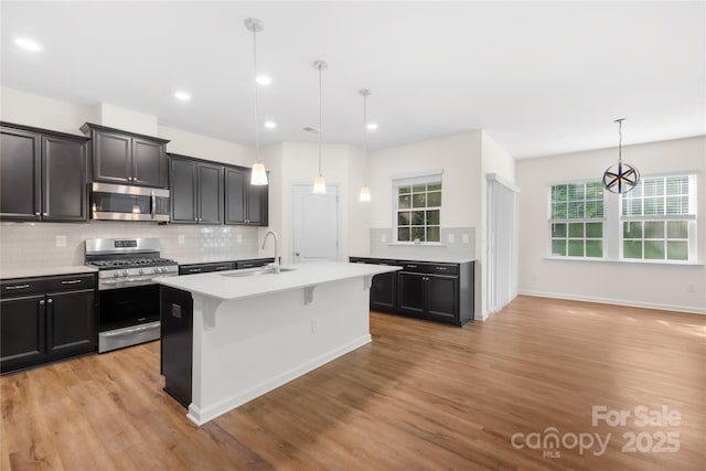 17413 Caddy Ct, Charlotte, NC 28278 - kitchen featuring appliances with stainless steel finishes, light countertops, light wood-style flooring, backsplash, and recessed lighting