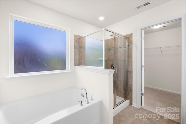 17413 Caddy Ct, Charlotte, NC 28278 - bathroom with a garden tub, a shower stall, a walk in closet, and tile patterned floors