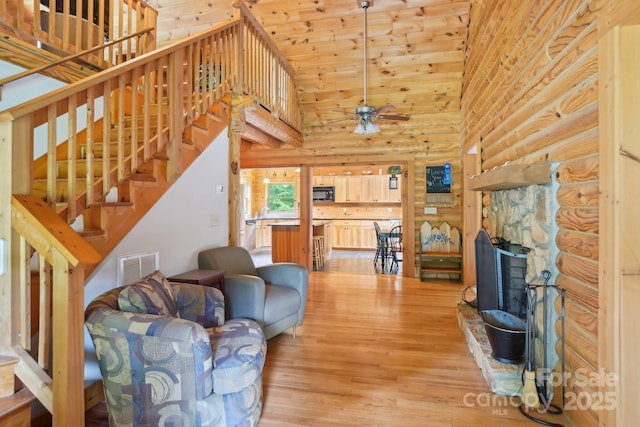 10583 Earnhardt Lake Rd, Davidson, NC 28036 - living area with light wood-style flooring, ceiling fan, high vaulted ceiling, stairway, and rustic walls