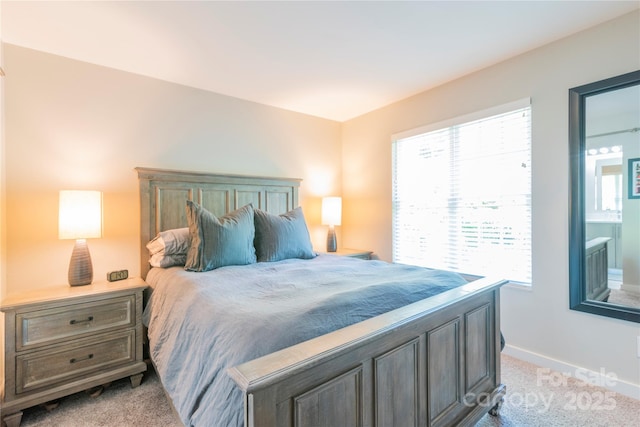 bedroom with light colored carpet and baseboards