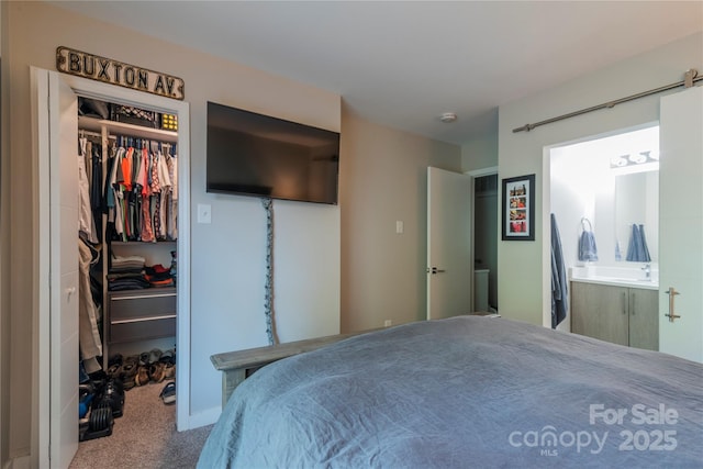 bedroom with ensuite bath, carpet flooring, a spacious closet, and a closet