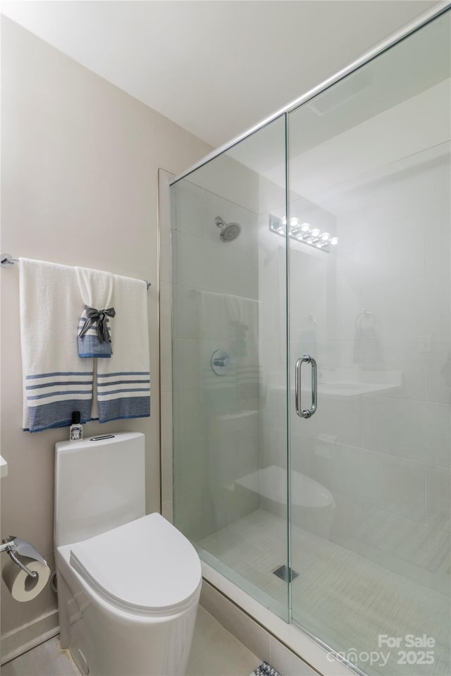 full bath featuring a shower stall and toilet