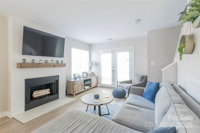 living room with french doors, wood finished floors, visible vents, and a fireplace