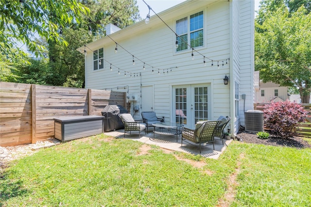 rear view of house featuring a lawn, a fenced backyard, french doors, and a patio