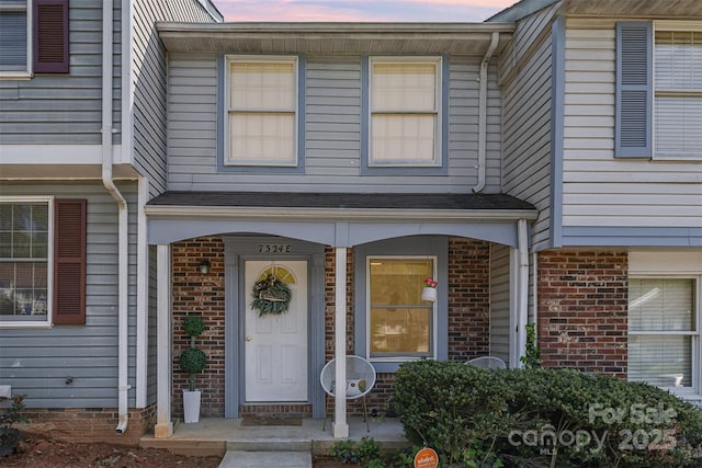 7324 Pebblestone Dr Unit E, Charlotte, NC 28212 - exterior entry at dusk with brick siding and covered porch