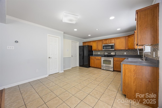 4219 Shasta Cir, Clover, SC 29710 - kitchen featuring stainless steel appliances, crown molding, dark countertops, decorative backsplash, and brown cabinets
