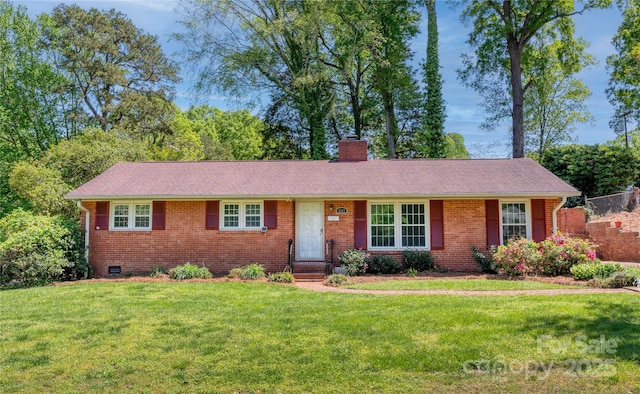 ranch-style house with a front yard, roof with shingles, brick siding, and a chimney