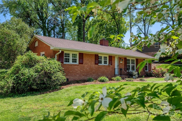 ranch-style house featuring brick siding, a front lawn, and a chimney
