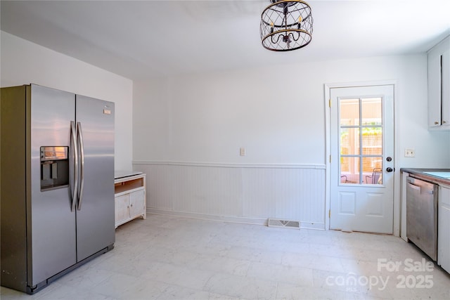 kitchen featuring wainscoting, visible vents, an inviting chandelier, and appliances with stainless steel finishes