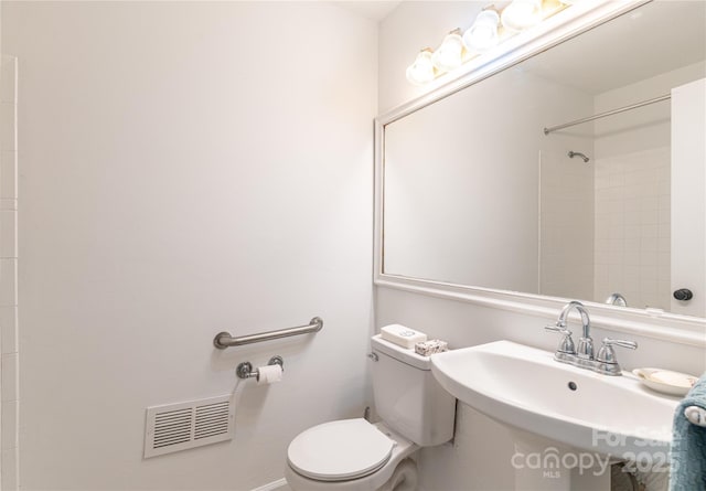bathroom with walk in shower, visible vents, a sink, and toilet