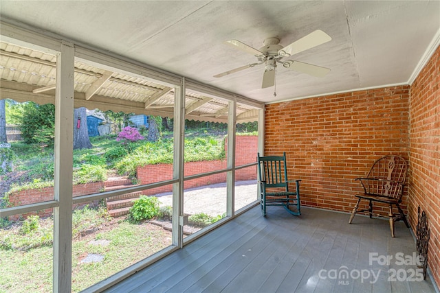 unfurnished sunroom with ceiling fan