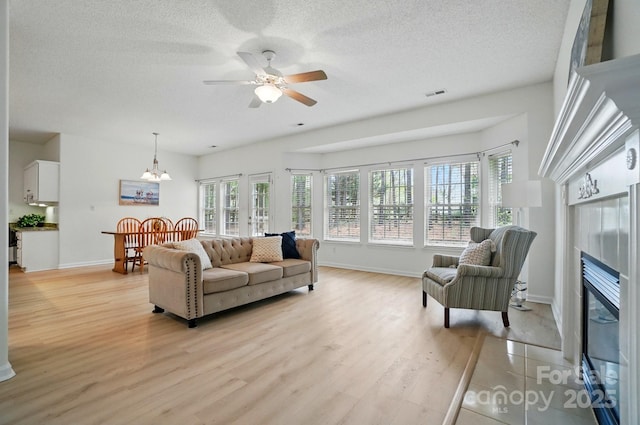 212 Kilborne Rd, Mooresville, NC 28117 - living room with visible vents, plenty of natural light, a glass covered fireplace, and light wood-style floors