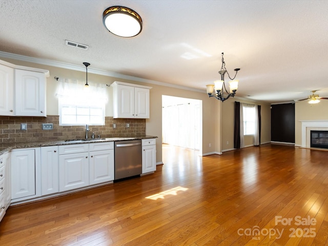 kitchen featuring dishwasher, visible vents, a sink, decorative backsplash, and open floor plan