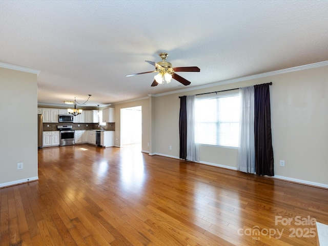 unfurnished living room with crown molding, wood finished floors, and ceiling fan with notable chandelier