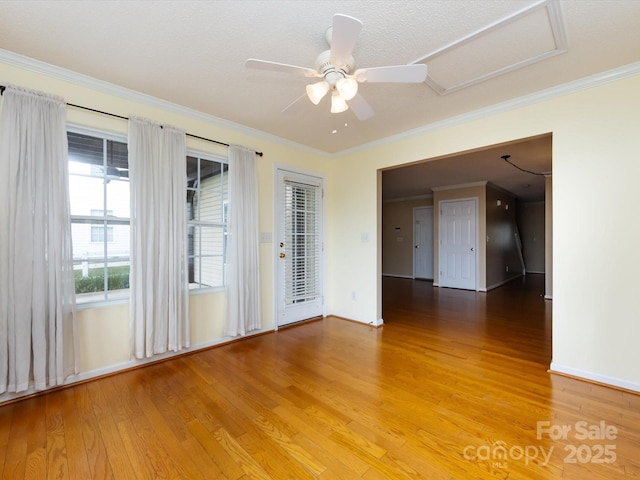 spare room with ceiling fan, crown molding, and light wood-style floors