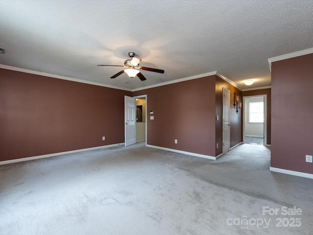 empty room featuring carpet flooring, a textured ceiling, baseboards, ceiling fan, and crown molding