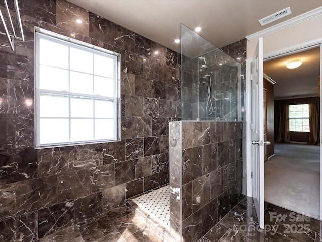 bathroom with a walk in shower, crown molding, and visible vents