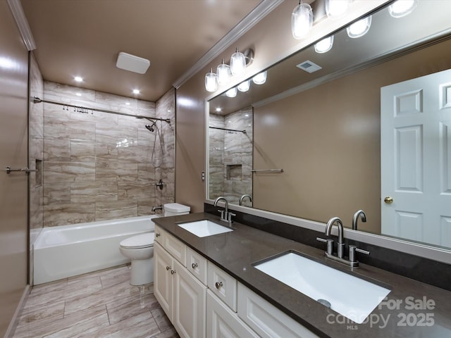 full bathroom with toilet, ornamental molding, a sink, and visible vents