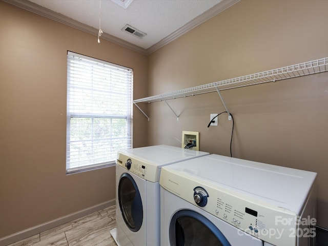washroom with baseboards, visible vents, separate washer and dryer, crown molding, and laundry area