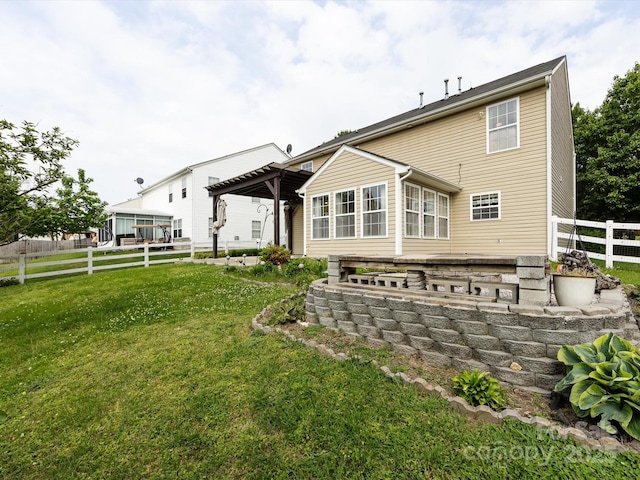 rear view of property featuring fence, a lawn, and a pergola