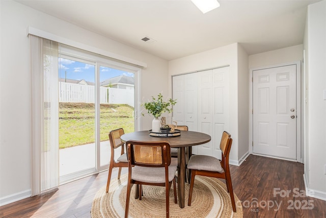 dining room with visible vents, baseboards, and dark wood-style floors