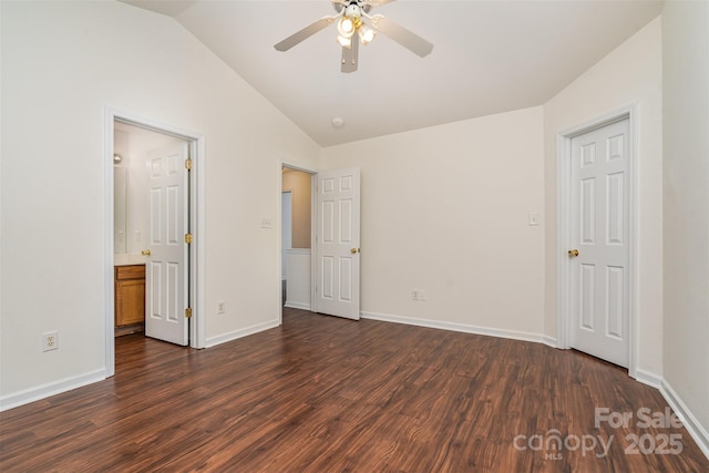 unfurnished bedroom with baseboards, dark wood-style floors, and lofted ceiling