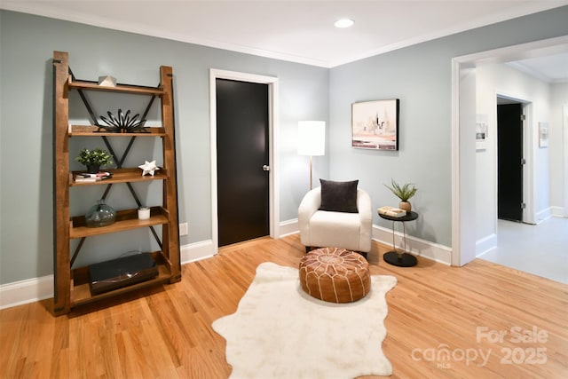 living area featuring crown molding, wood finished floors, baseboards, and recessed lighting
