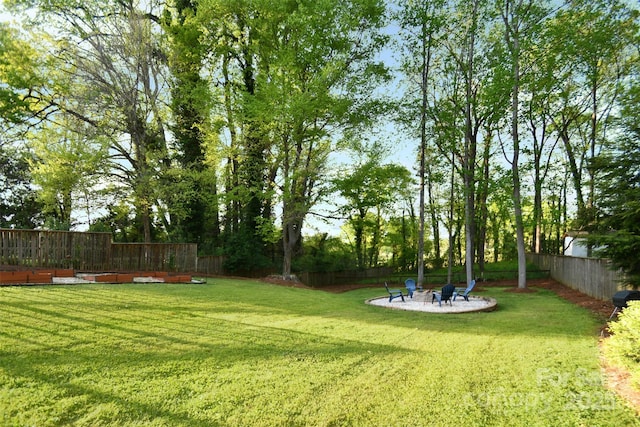 view of yard with an outdoor fire pit, a patio, and a fenced backyard