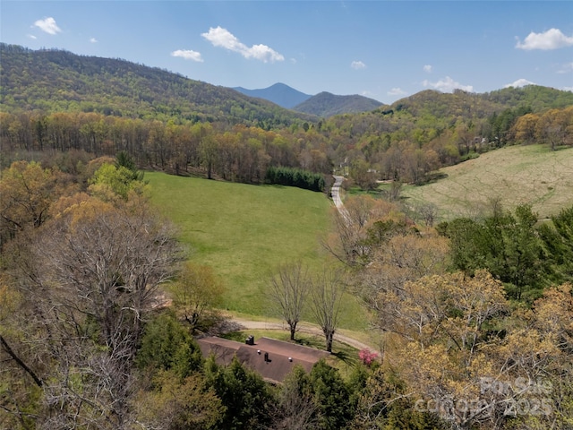 aerial view with a wooded view and a mountain view