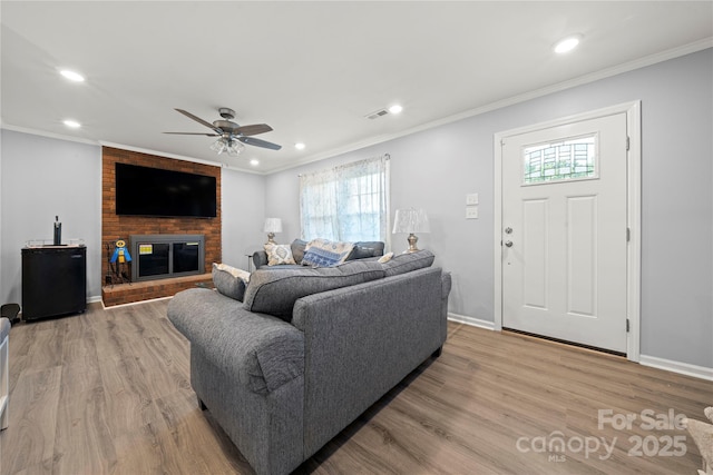 living area featuring a ceiling fan, plenty of natural light, and light wood-style floors