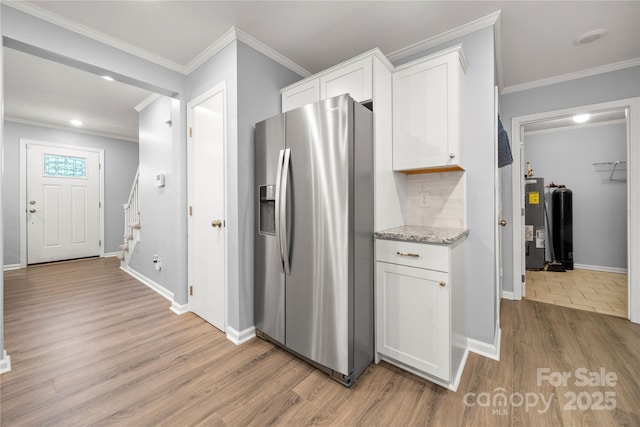 kitchen with stainless steel fridge with ice dispenser, water heater, light wood-style flooring, white cabinetry, and crown molding
