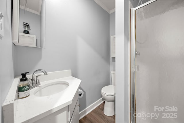 bathroom with a stall shower, toilet, wood finished floors, crown molding, and vanity