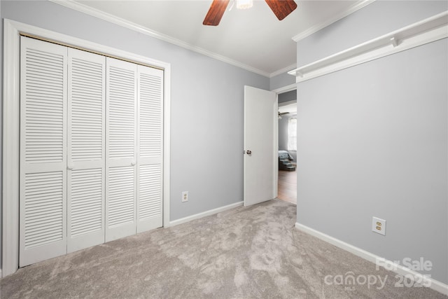 unfurnished bedroom featuring carpet flooring, baseboards, a ceiling fan, a closet, and ornamental molding